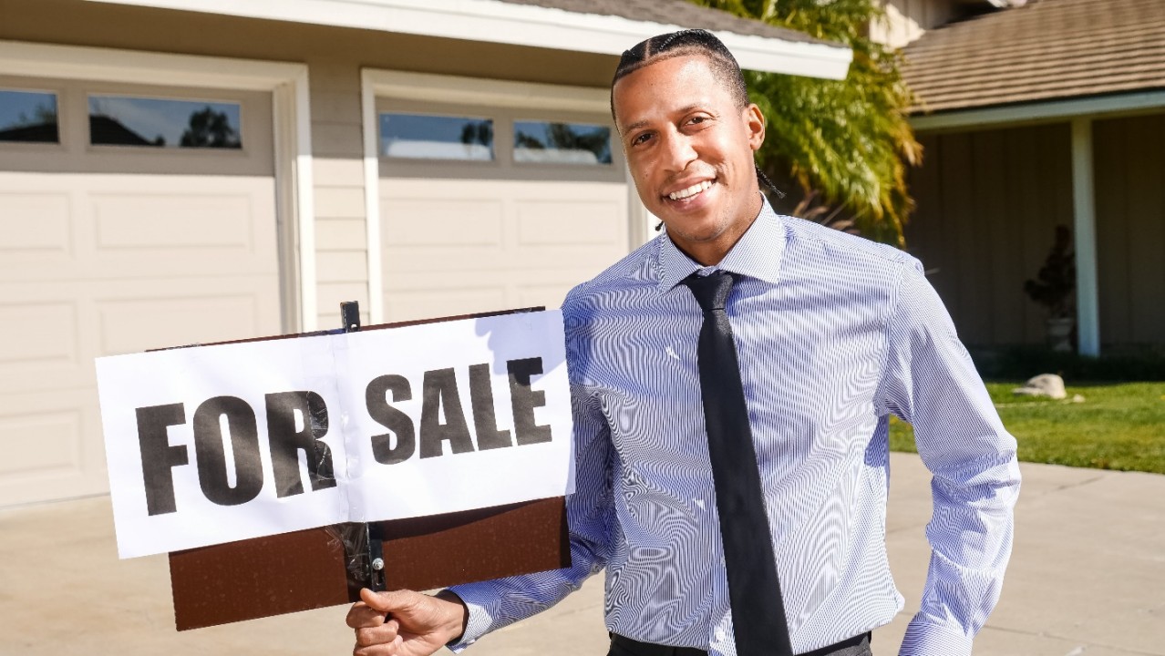 Realtor Holding a Sign
